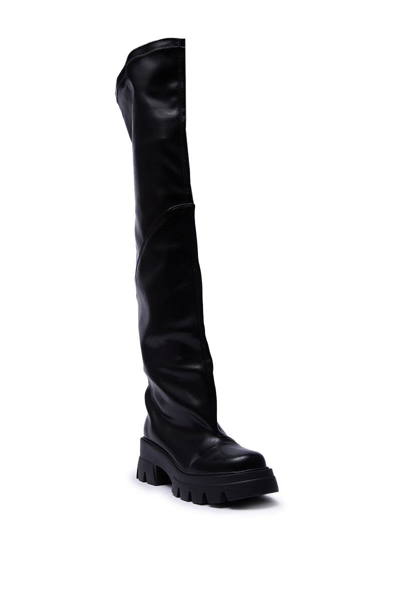The AZALEA WANG RONAN BLACK SLOUCH BOOT is a single black, knee-high faux leather boot with a chunky treaded sole and a slightly slouchy shaft, shown upright against a white background.