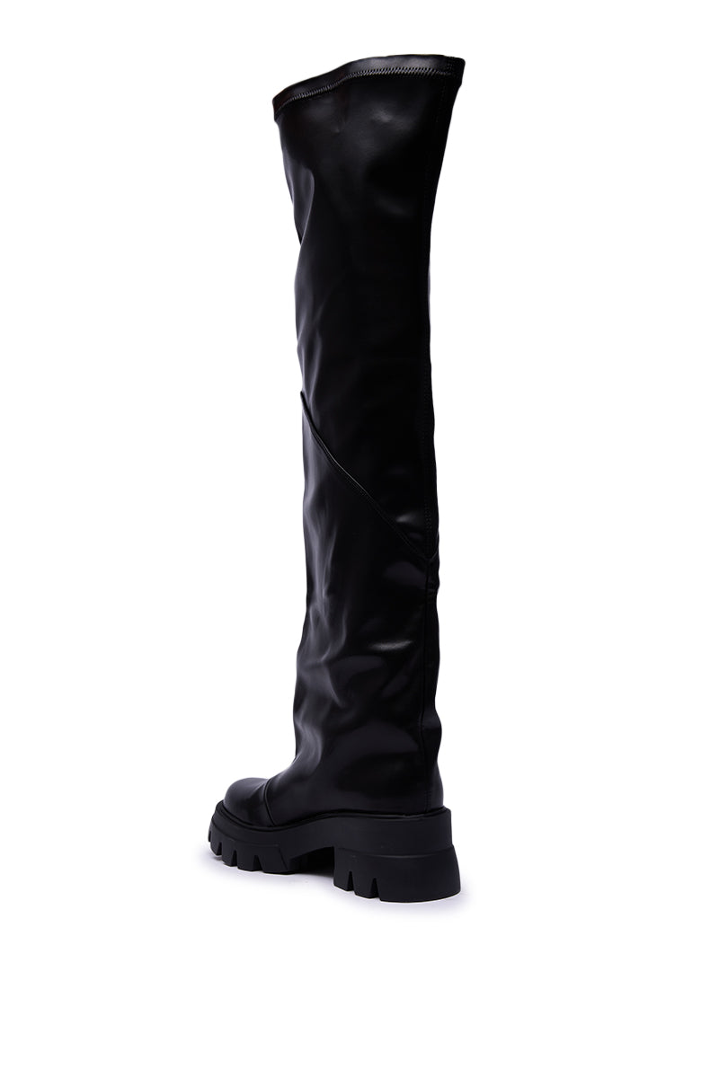 The AZALEA WANG RONAN BLACK SLOUCH BOOT is a single knee-high, black faux leather boot with a chunky sole and slouched texture, shown at an angle on a white background.