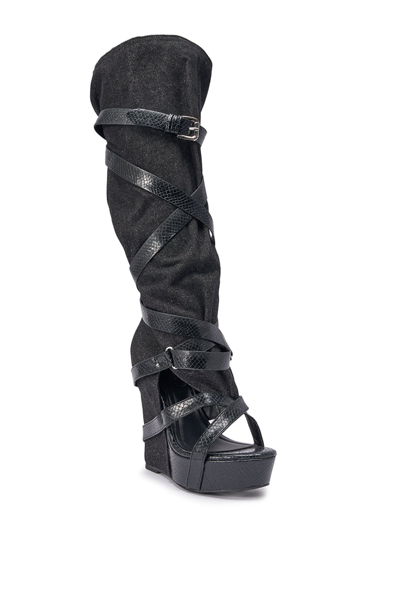 The AZALEA WANG ROTHKID Black Denim Knee High Open Toe Boot features crisscrossing black faux leather straps, a wedge heel, and a textured knee-high denim shaft. 4