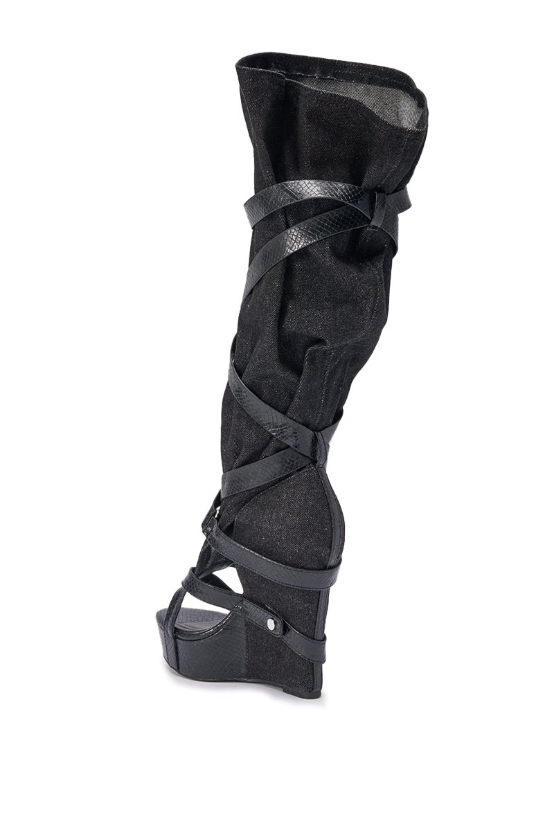 The AZALEA WANG ROTHKID Black Denim Knee High Open Toe Boot features crisscrossing leather straps, a slouchy suede shaft, and a flat sole, showcased against a white background. 5