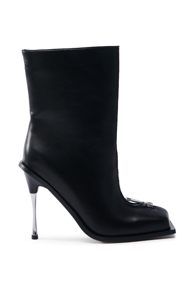 The AZALEA WANG ROUSSE FRONT ZIP BOOT IN BLACK is a sleek faux leather boot with a glossy silver stiletto heel, square toe, and metallic embellishment near the front, offering a blend of elegance and modern style.