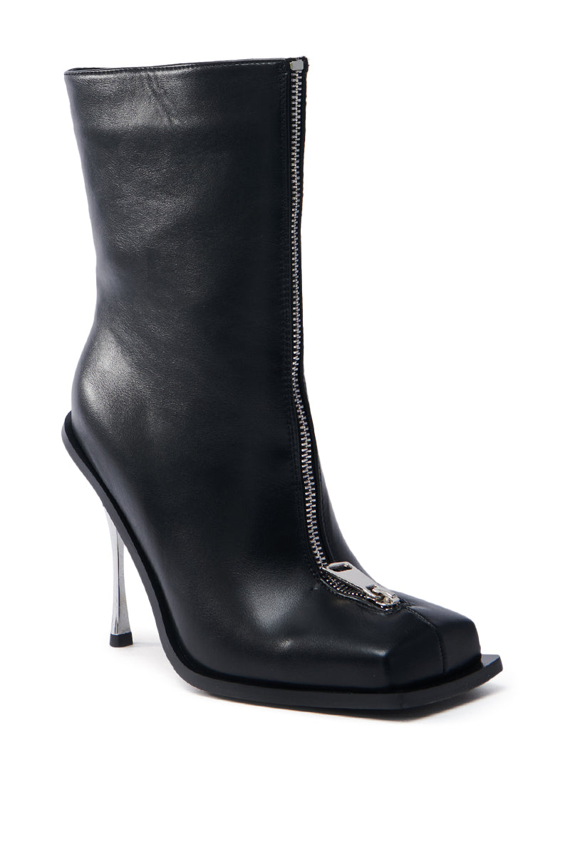 The AZALEA WANG ROUSSE FRONT ZIP BOOT IN BLACK is a faux leather ankle boot boasting a square toe and front silver zipper, paired with a unique high metallic stiletto heel for a modern touch.