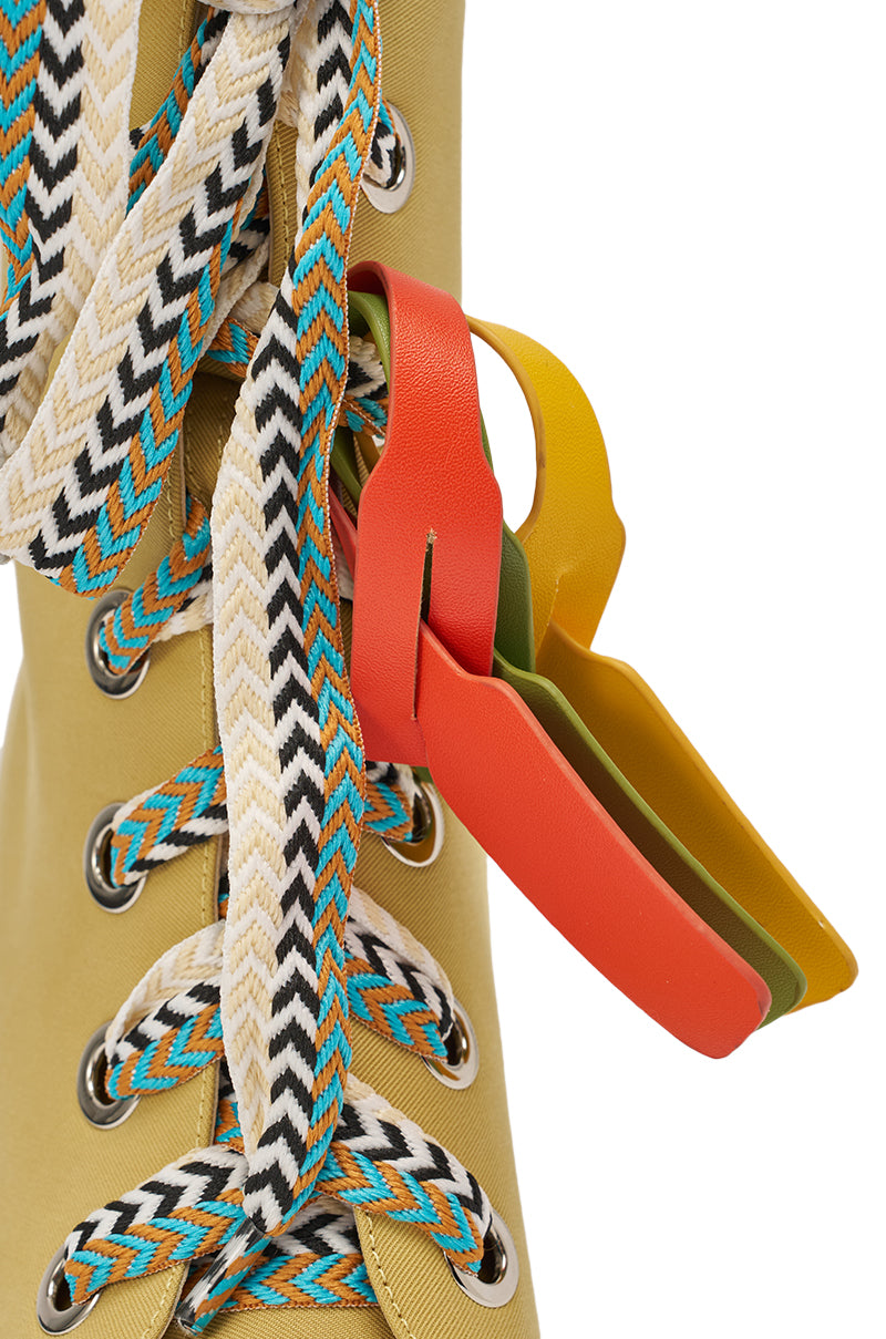 Close-up of the AZALEA WANG ROVEA KHAKI LACE UP STILETTO BOOTIE in beige fabric, featuring colorful zigzag-patterned laces in black, white, blue, and orange, plus red, green, and yellow tags on the laces. 8