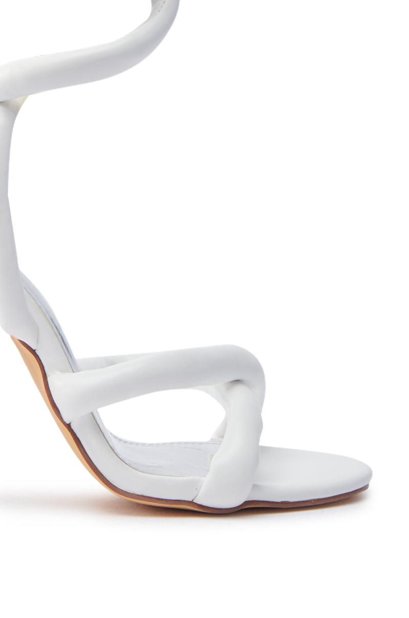The Royale White PU Puff Chunky Lace Up Sandal showcases a twisted strap design and minimalist aesthetic. Made from faux leather, it features an open almond toe, slim sole, and curved heel for modern elegance. 5