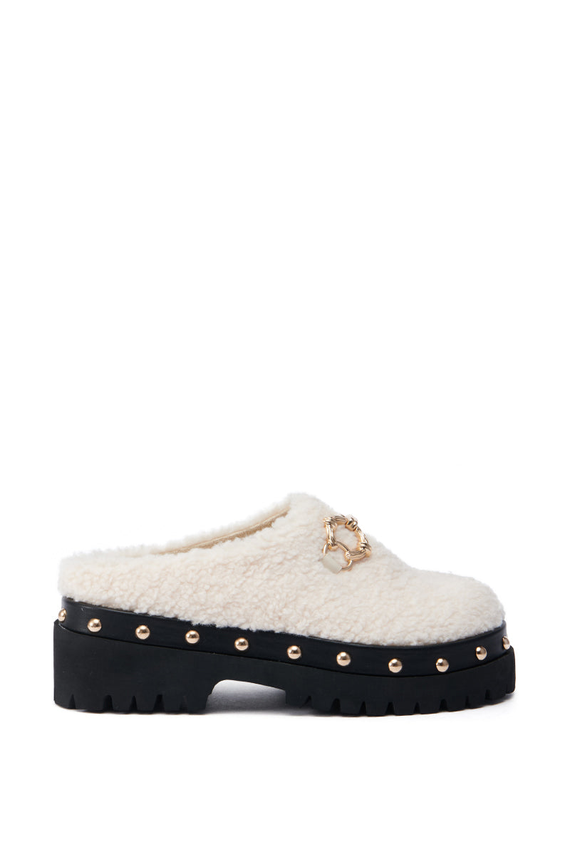 Introducing the AZALEA WANG ROZELE BEIGE CLOG: a chic shearling slip-on shoe with a plush, faux sherpa look. It features a platform lug sole, adorned with gold stud accents and a decorative gold chain on the upper for an added stylish touch.