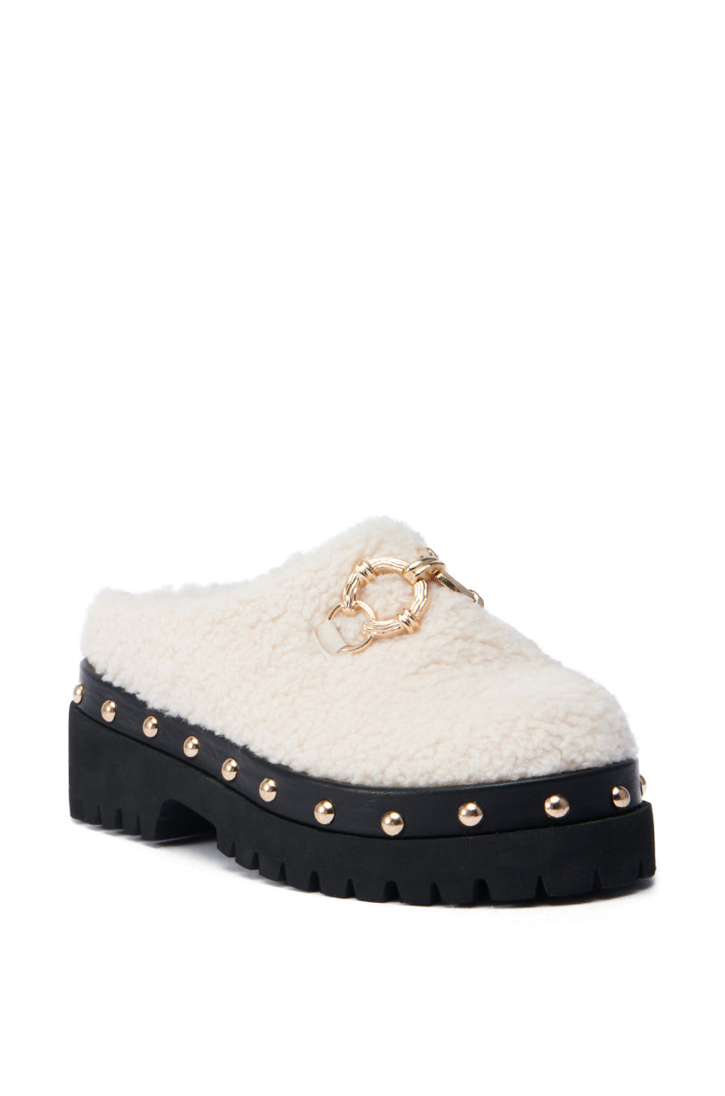 Introducing the AZALEA WANG ROZELE BEIGE CLOG, a slip-on mule featuring a fluffy white faux Sherpa upper and a distinctive chunky black sole. This stylish shoe is embellished with gold studs around its platform lug sole and boasts an eye-catching decorative gold chain on top.