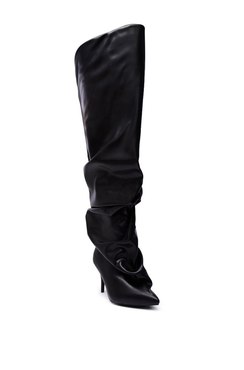 The AZALEA WANG RUBIUS BLACK EXTREME RUCHED BOOT is a shiny, slouchy knee-high boot featuring a pointed toe and high stiletto heel in faux leather, shown against a white background.
