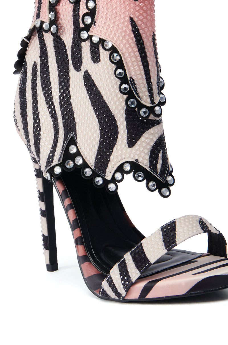 Introducing the AZALEA WANG RUMMIE TIGER STILETTO SANDAL, a chic sandal showcasing a zebra-inspired print with bold black and white stripes. This shoe is elegantly detailed with silver studs along the edge and rhinestone embellishments, complemented by a single front strap.