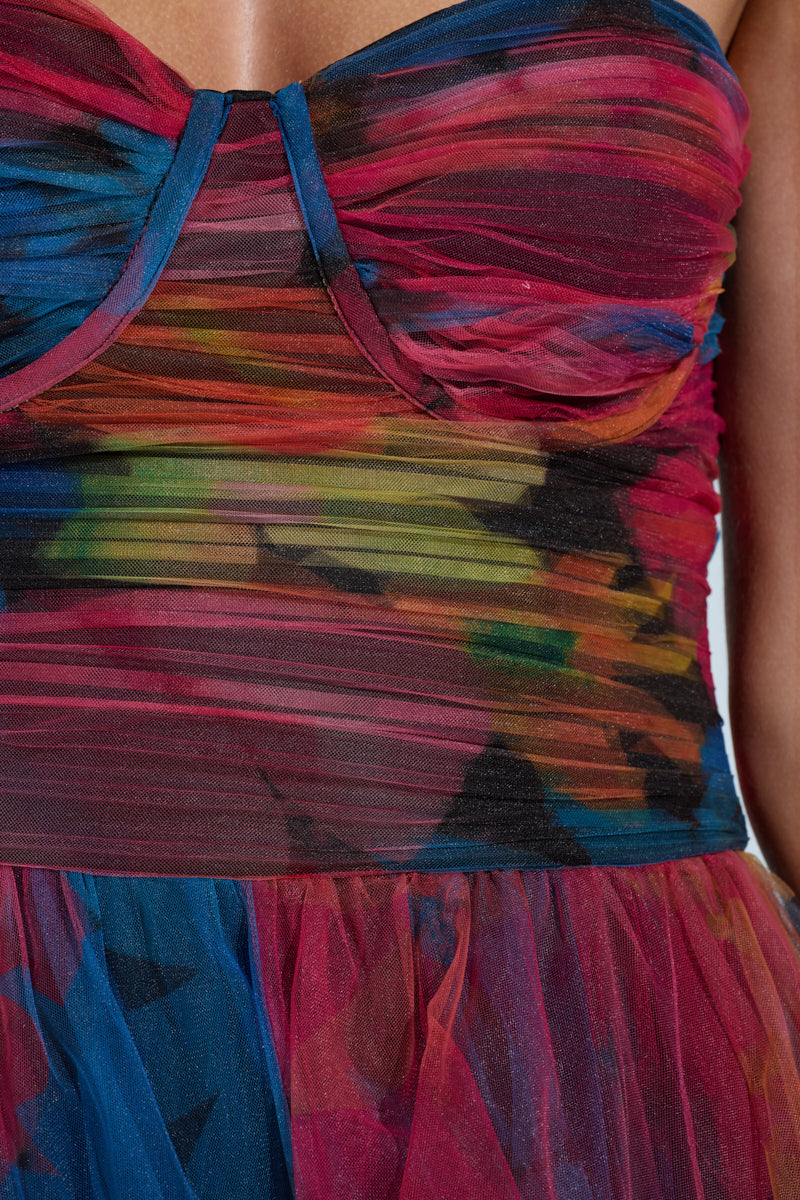 Close-up of the MEGAN STRAPLESS MAXI DRESS with vibrant ruched, layered fabric in blue, red, pink, and green hues accented with black. The textured flow resembles tulle mesh and is subtly adorned with floral patterns.