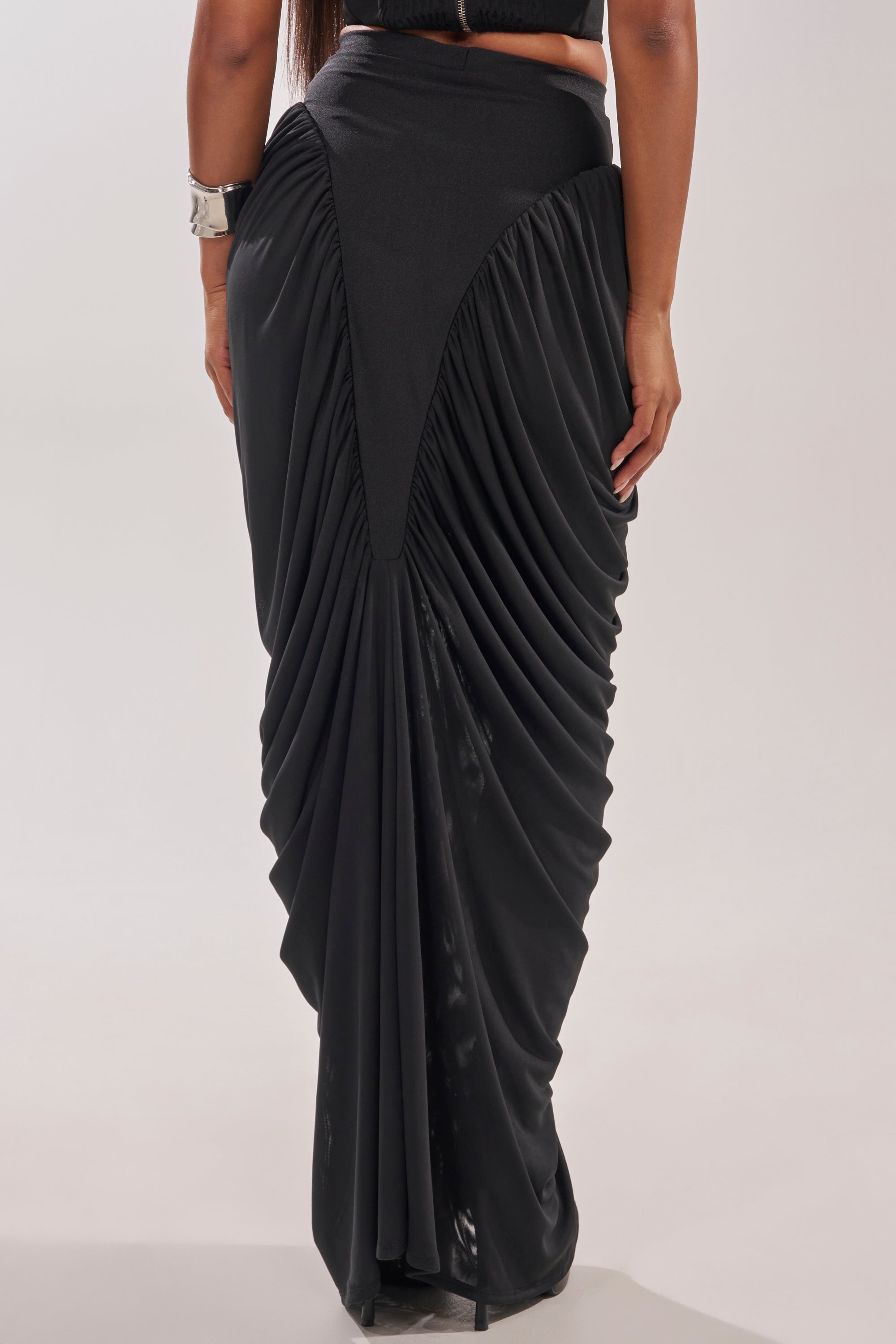 A person models the DREAMY RUCHED SKIRT—a black high-rise maxi with gathered pleats—against a plain light background, showing only the lower body. 4