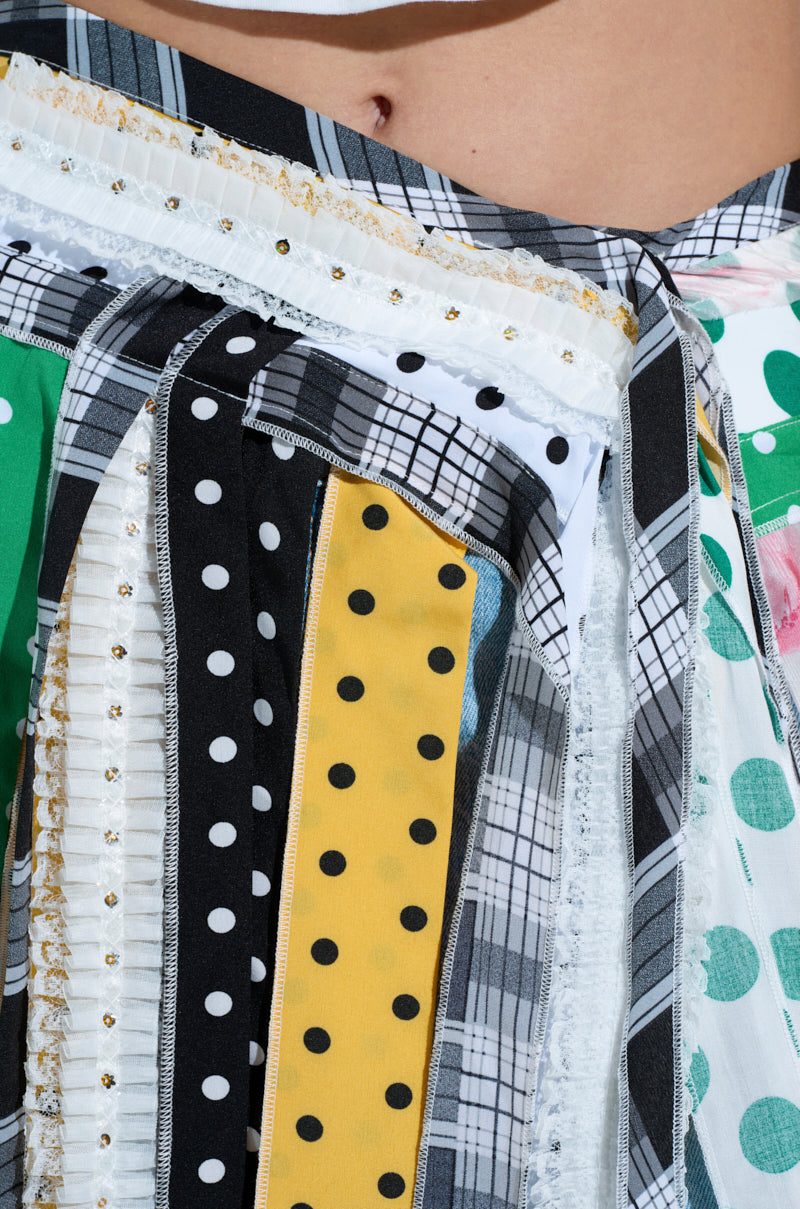 The OH SO CHIC PATTERN MIX BELT SKIRT showcases stripes, polka dots, and plaid patterns in black, white, yellow, green, and pink. Embellished with lace and small beads, it features an adjustable snap button waistband for a perfect fit.