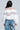 A person with long hair, facing away, is wearing a stylish ivory sweatshirt called the 