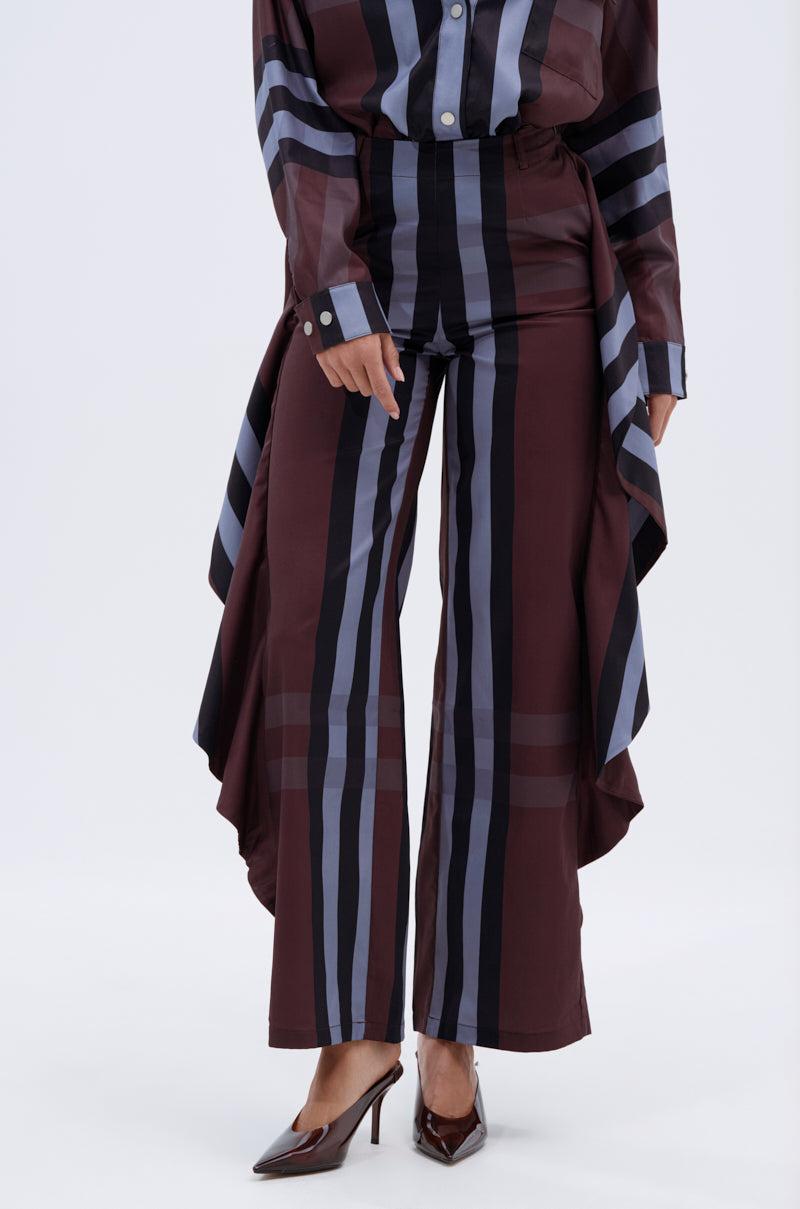 A person wearing LUXURY LIFE PLAID PALAZZO PANT with vertical black and gray stripes, a matching long-sided shirt, and brown pointed high heels stands against a plain white background.
