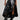 A person wearing the KEEP WALKING MIDI SKIRT, a black asymmetrical faux leather skirt, paired with high-rise black boots stands against a light gray background, showcasing an edgy and bold fashion style.