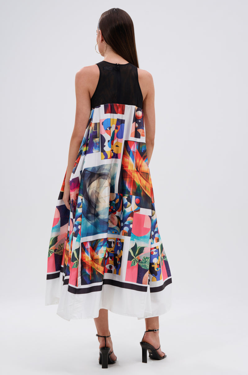 A woman with long brown hair wears the PUT ME IN A MUSEUM PRINTED MIDI DRESS, showcasing colorful abstract and geometric patterns. She stands with her back to the camera, paired with black heeled sandals.