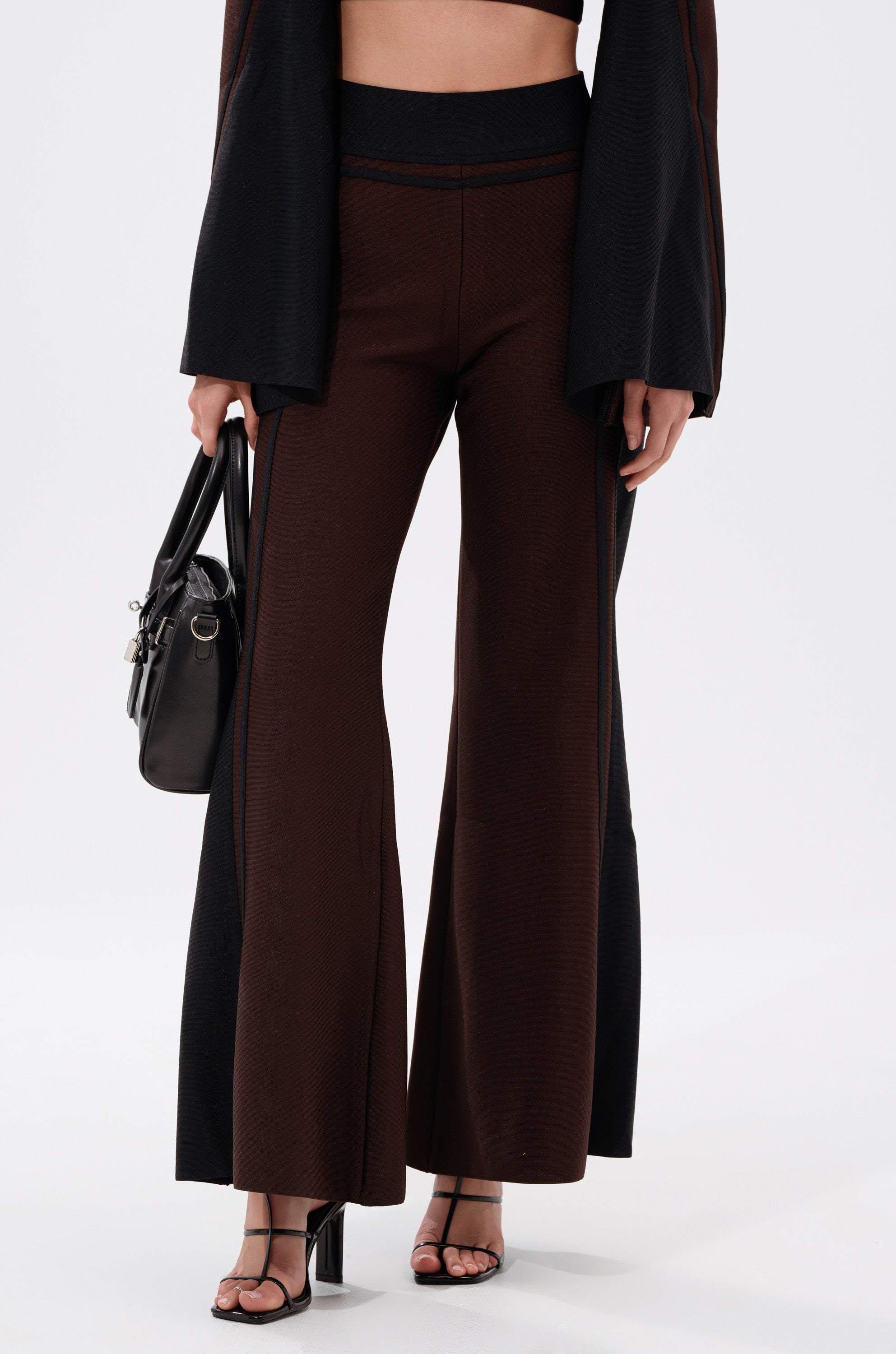 A woman wearing the MAZIE WIDE LEG PALAZZO PANT in high-rise black and brown.