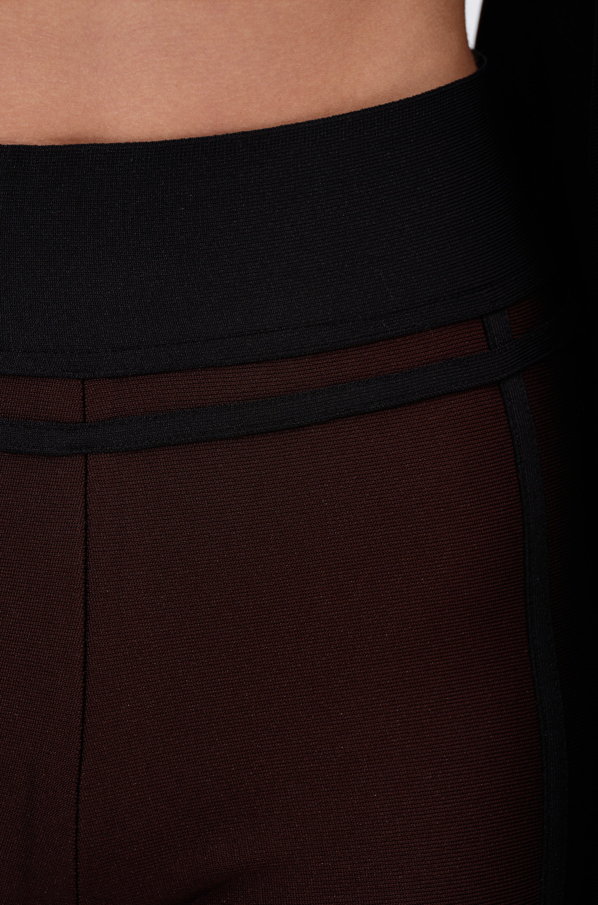 Close-up of a person wearing the MAZIE WIDE LEG PALAZZO PANT, featuring a black high-waisted design and wide-leg silhouette, highlighting the waistband and upper hip area.