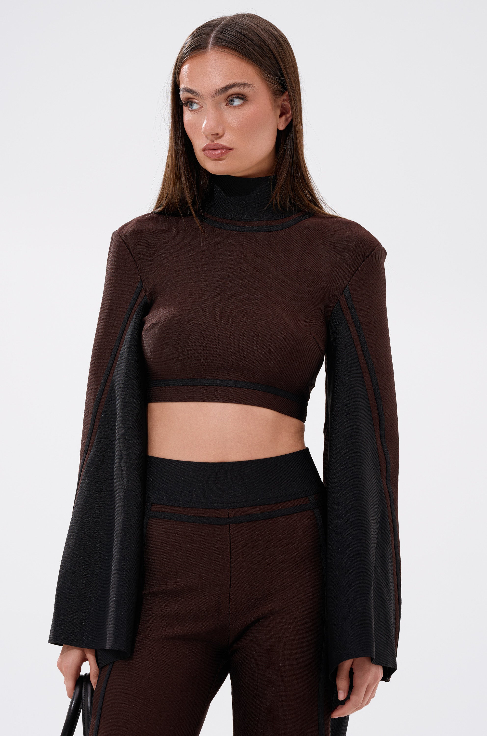 A woman wearing the MAZIE MOCK NECK SWEATER in brown.
