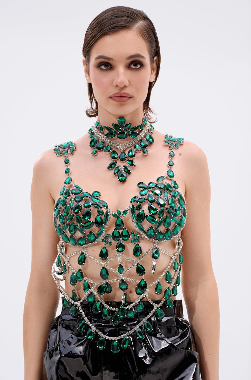 A woman with short brown hair wears the LUCKY ME RHINESTONE BLOUSE, a matching choker and necklace, and glossy black pants against a plain light background. 4