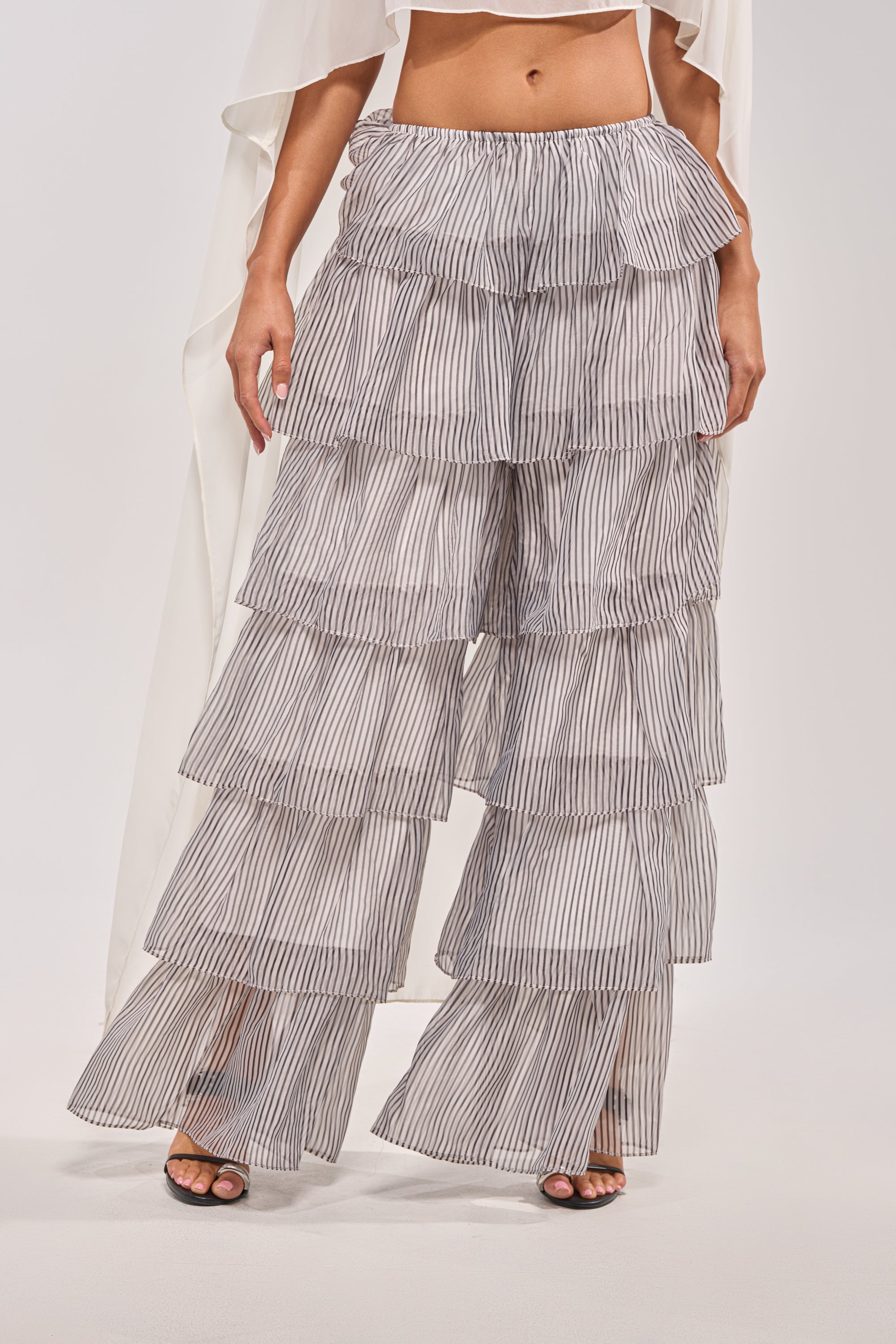 Someone styled the ALL I WANT TO DO STRIPE PALAZZO PANT—high-waisted, striped, with ruffled tiers and airy fabric—with open-toed shoes and a white top for a perfect spring festival look. 0