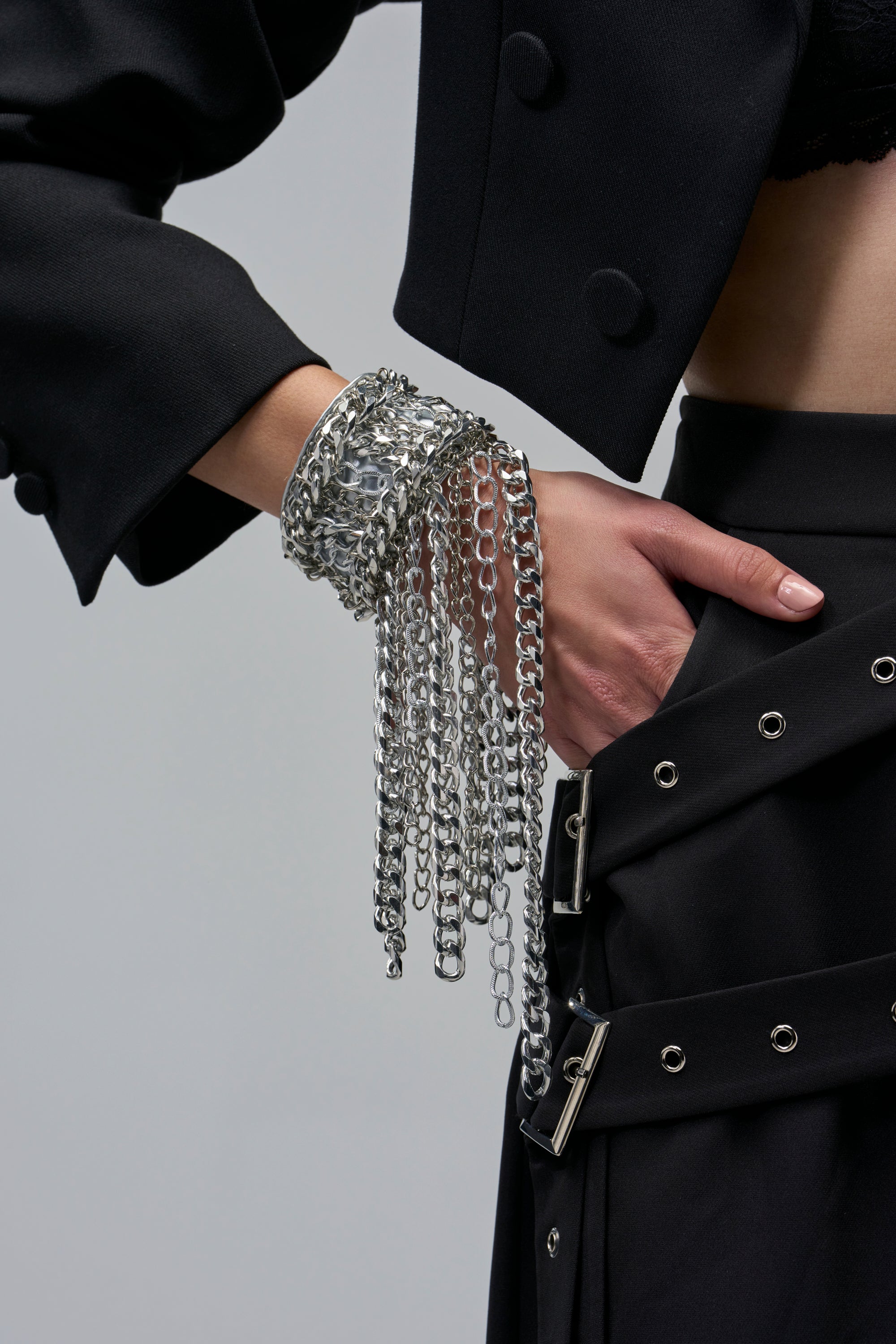 CHAINCORE BRACELET featuring a wide silver-toned chain cuff with multiple dangling strands worn on a person’s wrist.