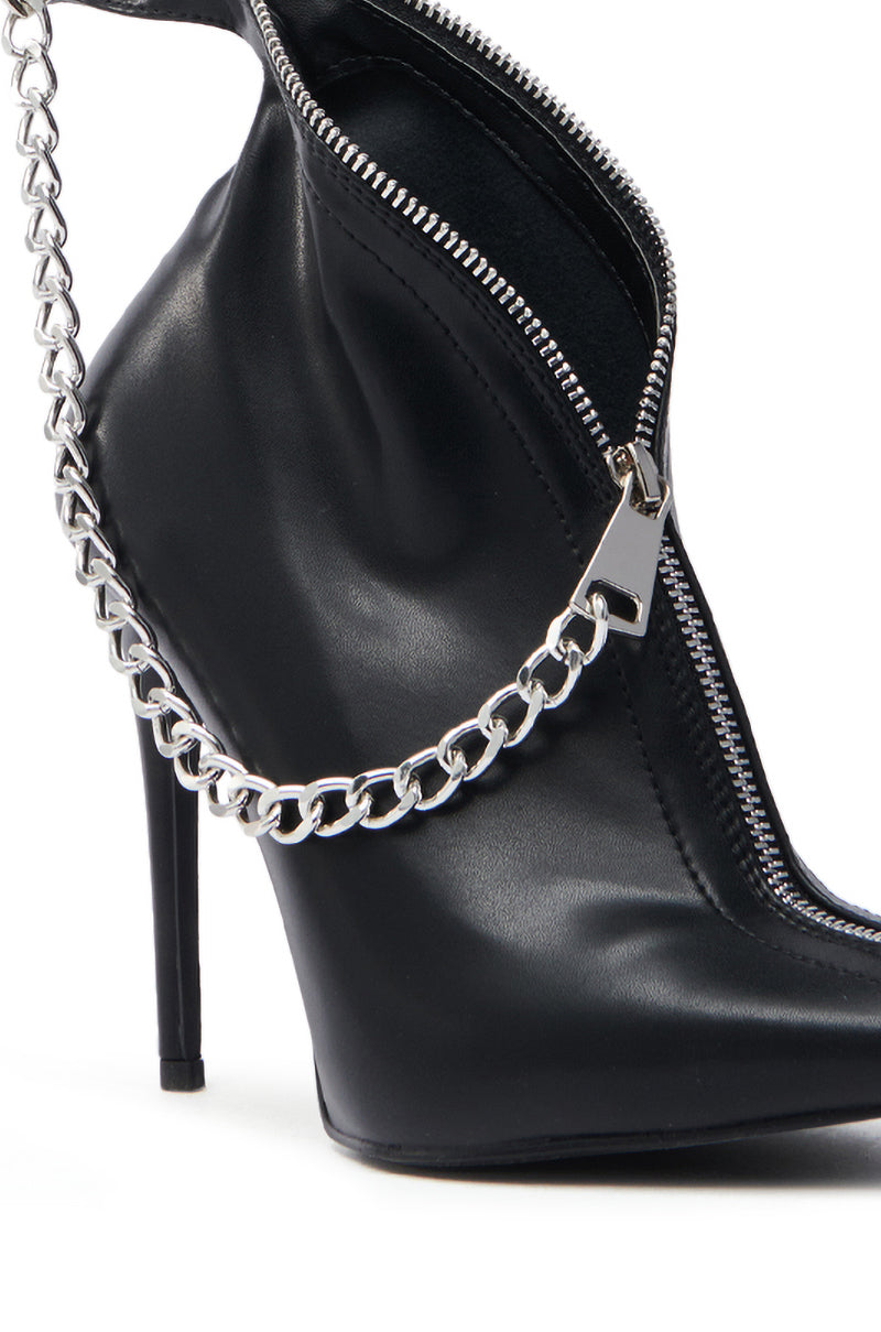 The AZALEA WANG SAGITTA BLACK STILETTO PUMP is a black high-heeled shoe crafted from glossy vegan leather, featuring a pointed toe, a prominent silver zipper on the side, and a decorative silver chain for a sleek, stylish look.