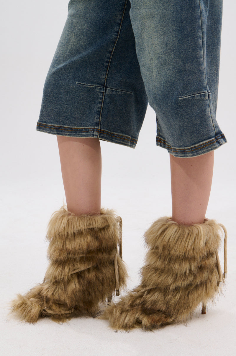 A person in cropped blue jeans stands on a white surface wearing AZALEA WANG SALERE BROWN ROPE DETAIL STILETTO BOOTIE heels, featuring shaggy brown faux fur and subtle rope accents.
