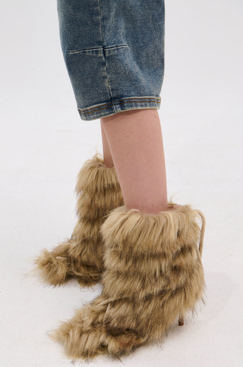 A person wearing knee-length denim shorts and the AZALEA WANG SALERE Brown Rope Detail Stiletto Bootie stands on a white surface.