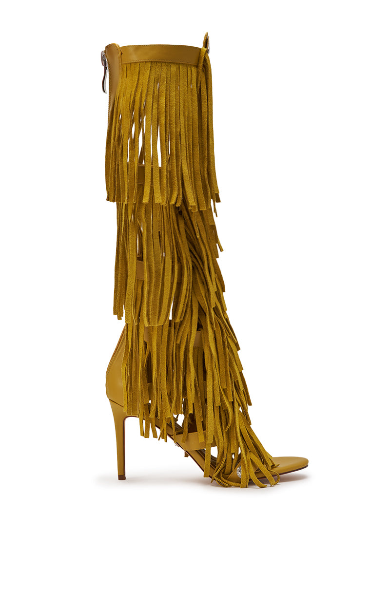 The AZALEA WANG SAMEYANA Mustard Fringe and Metal Stiletto Gladiator Sandal is a knee-high, open-toe sandal featuring layers of long suede fringe from ankle to knee and a bold metal stiletto heel. 3