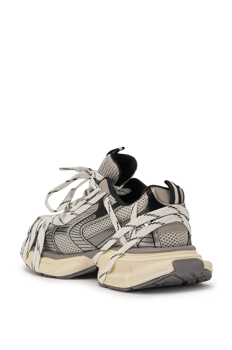 The AZALEA WANG SAMURAI GREY MULTI CHUNKY SNEAKER features gray and beige mesh panels, thick textured platform soles, and oversized white crisscross laces, shown angled to highlight their bold street-style appeal. 5