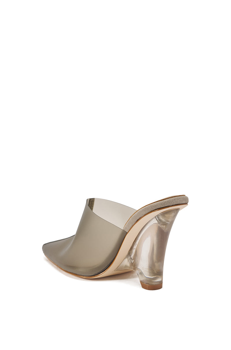 The AKIRA GOLD SANCTUS GREY PVC PUMP is a high-heeled, open-back mule featuring a transparent taupe upper and a clear, flared heel, shown from the rear.