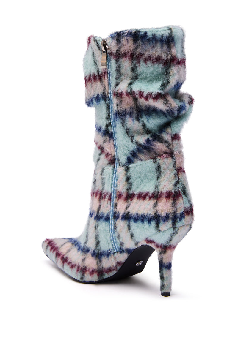 The AZALEA WANG SANJIV BLUE MULTI PLAID STILETTO BOOTIE is a mid-calf boot with fuzzy blue, burgundy, and cream plaid fabric, a pointed toe, side zipper, and a slim high heel for standout style.