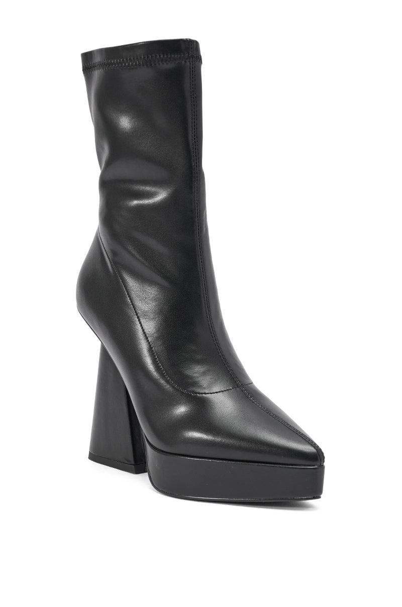 The AZALEA WANG SAXTON BLACK PU CHUNKY POINTED TOE BOOTIE features a high platform, bold block heel, and sleek pointed toe in smooth black PU, displayed against a white background. 5