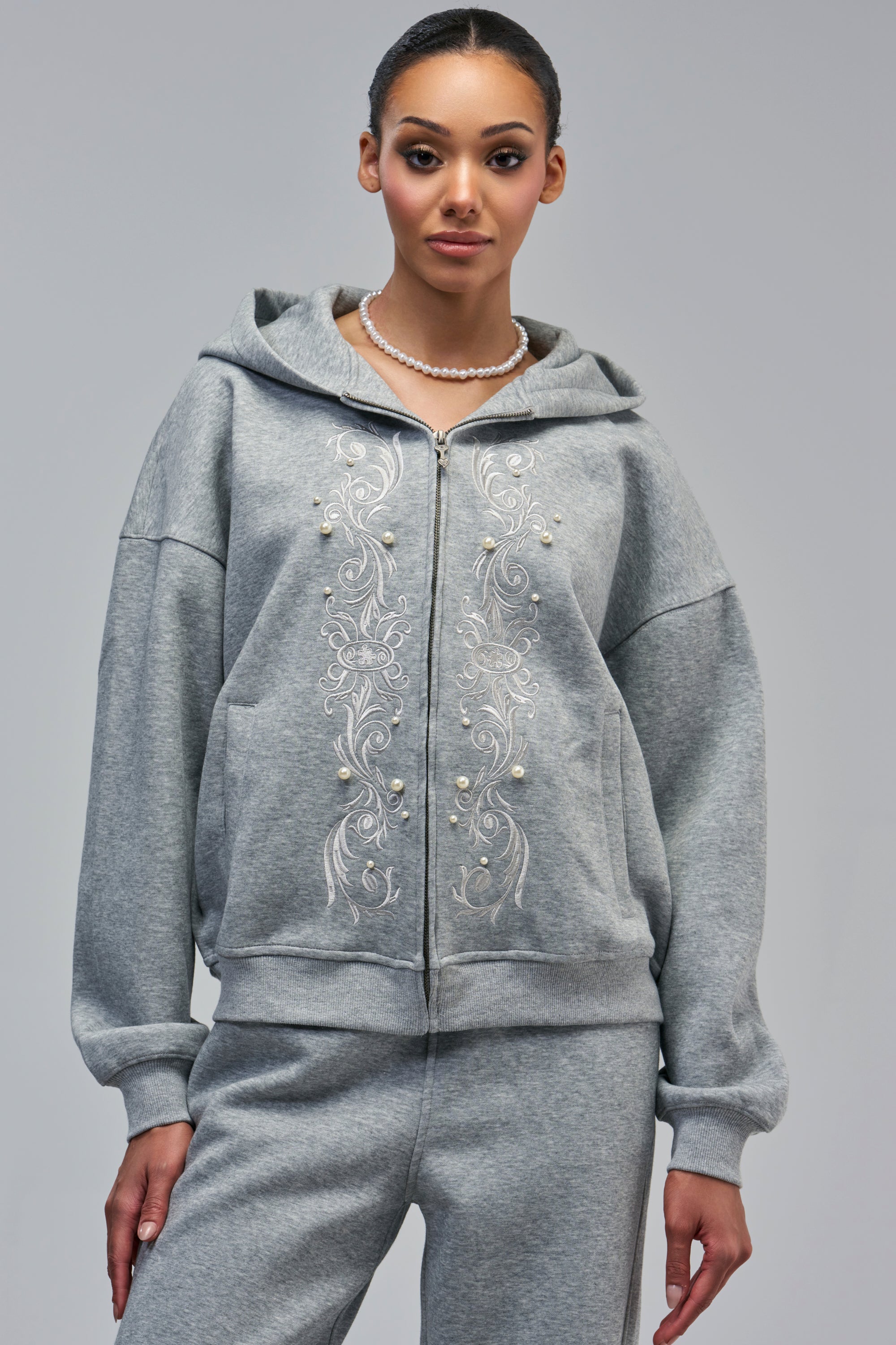 ANSON GREY SWEATSHIRT, an oversized heather grey zip-up hoodie featuring white embroidery and pearl accents on the front.