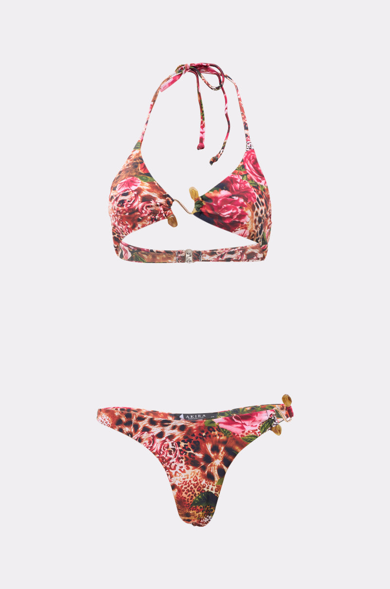 The WILD CHILD SWIMSUIT is a two-piece bikini with bold floral and leopard prints. The halter neck top has gold-tone hardware, and the matching bottoms feature gold embellishments on one side. 0