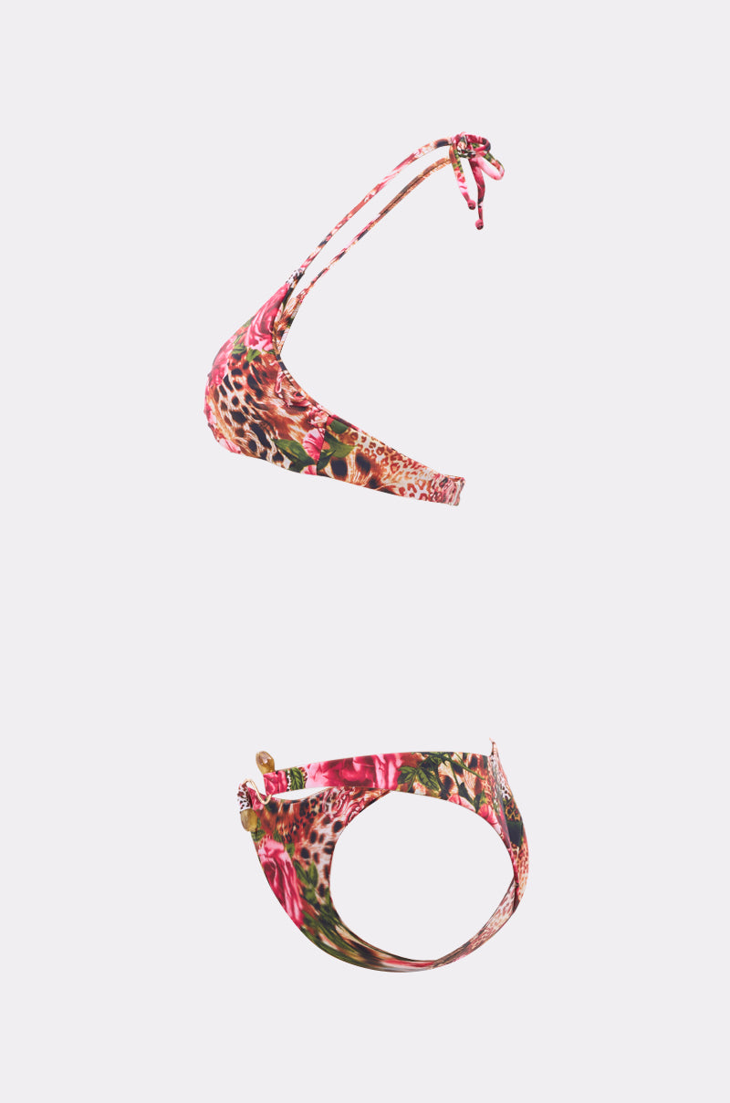 The WILD CHILD SWIMSUIT is a vibrant bikini set with a one-shoulder top and matching bottoms, showcasing bold floral and leopard prints on a light background, finished with chic gold-tone hardware. 1