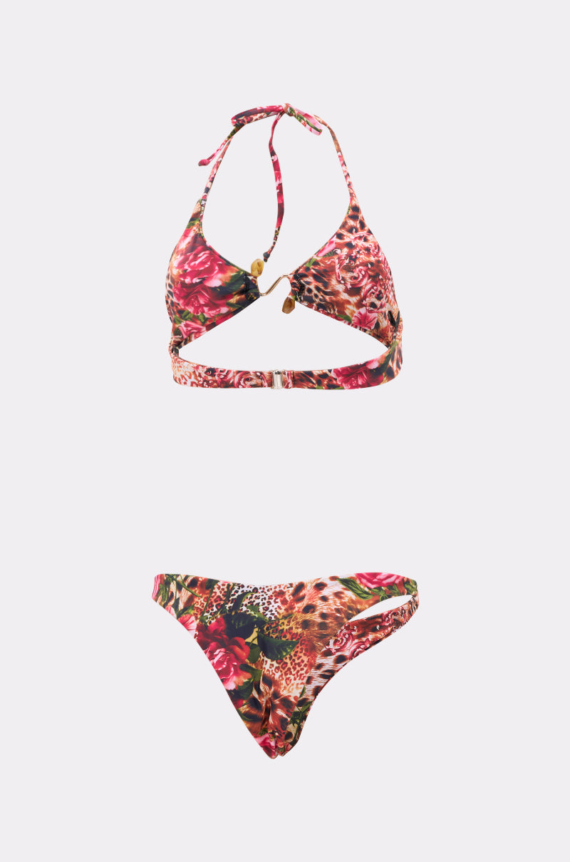 The WILD CHILD SWIMSUIT is a two-piece bikini with a halter neck top and matching bottoms, showcasing vibrant red, pink, and brown floral and leopard prints on a light background with chic gold-tone hardware accents. 2
