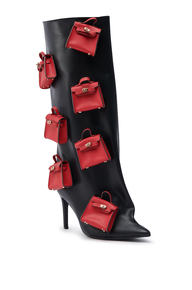 The AZALEA WANG SCIPIO BLACK PURSE BOOT is a black faux leather, knee-high stiletto boot adorned with multiple small red handbag accessories attached to the side.