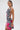 Model wears the WILD THANG PRINTED MINI DRESS, a sleeveless zebra print mini dress with vibrant tropical flowers, a large pink floral design, and side cutout, set against a plain white background.