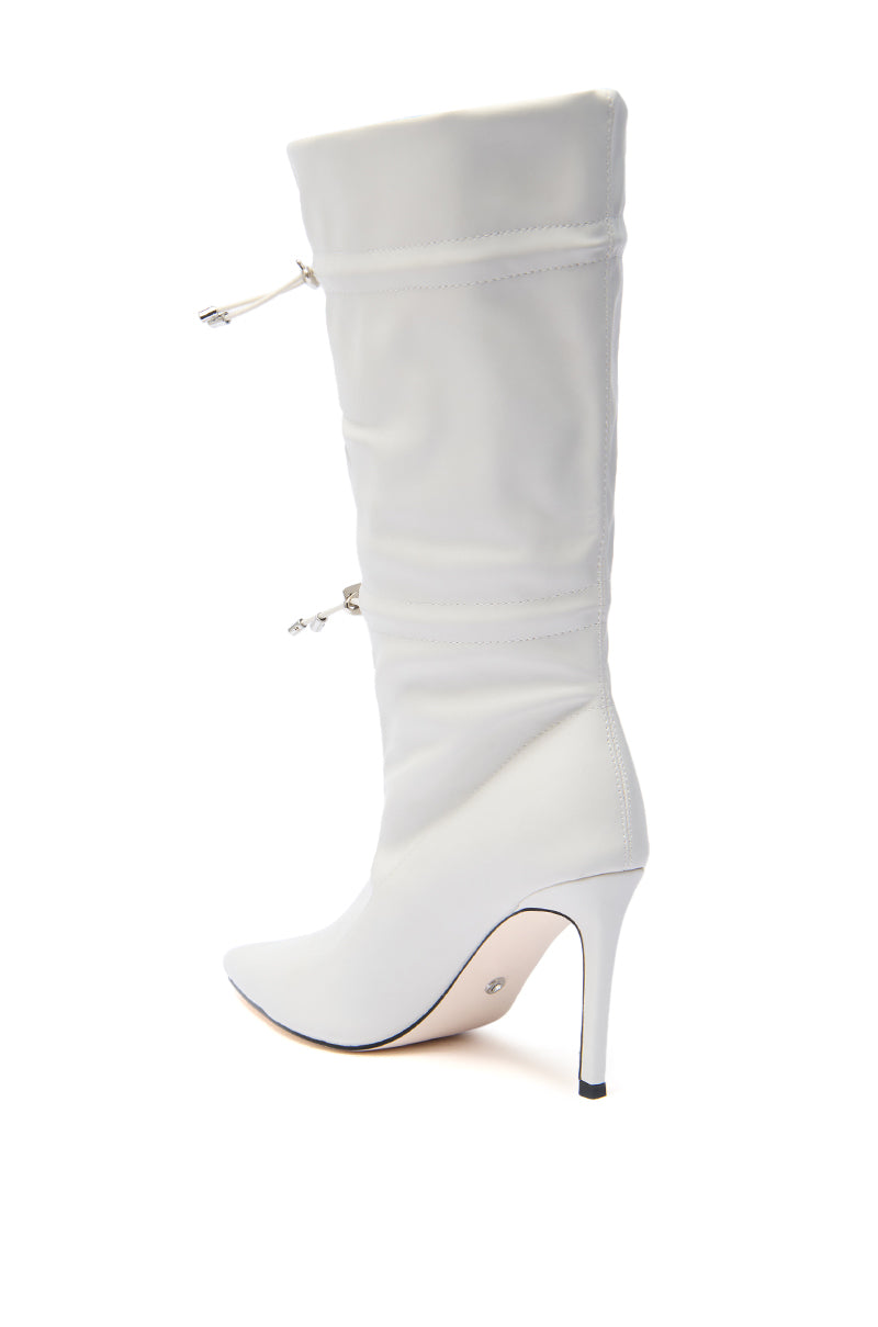 The AZALEA WANG SEANNA IVORY CINCHED STILETTO BOOTIE is a white, mid-calf boot with a pointed toe, stiletto heel, decorative seams, and two silver drawstring details near the top, shown on a plain white background. 3