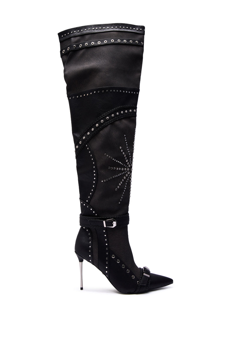 The AZALEA WANG SEASON BLACK MULTI EMBELLISHED STILETTO BOOT is an over-the-knee black boot with silver studs, decorative stitching, a pointed toe, thin high heel, and buckle straps around the ankle and instep for added style.