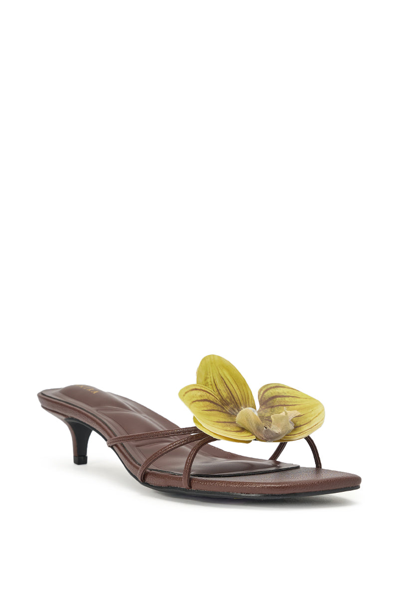 The AKIRA SELA CHOCOLATE SLIP ON FLOWER SANDAL is a chic faux leather brown sandal with thin straps, a stylish kitten heel, and a bold yellow flower—perfect summer resort footwear. 3