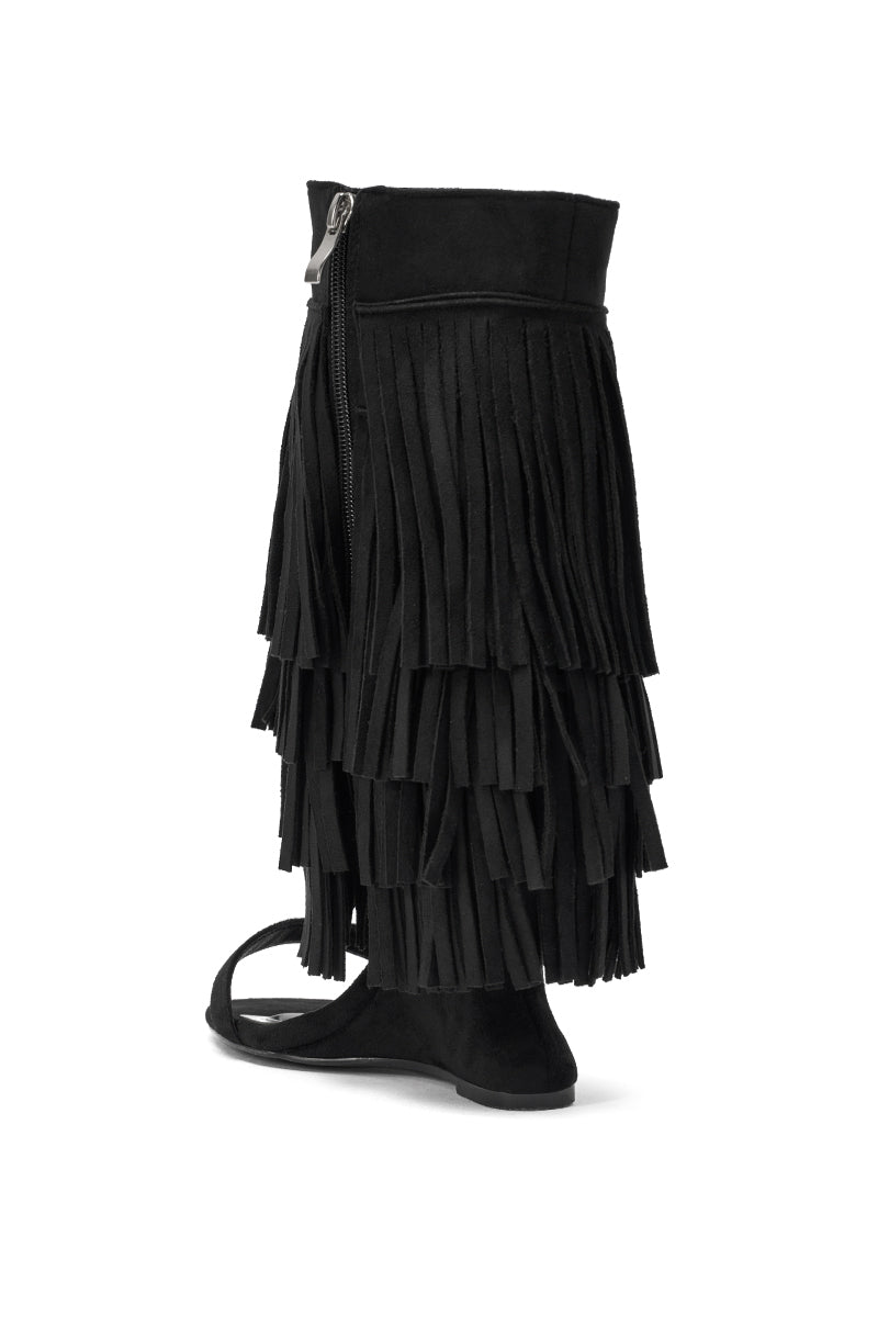 The AKIRA GOLD SESTINA Black Faux Suede Fringe Wedge Sandal features a tall, multi-fringed shaft, open toe, side zipper closure, and a sleek wedge heel. 5