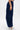 A person in profile wears FEEL GOOD TROUSER in navy with large cargo pockets and a high-rise elastic waistband, paired with silver heels, set against a plain white background.
