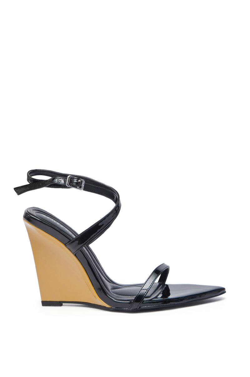 The AZALEA WANG SEUNG BLACK COLOR BLOCKED HEEL WEDGE SANDAL features a glossy black faux leather upper, thin ankle strap with buckle, tan color-blocked wedge heel, open pointed toe, and sleek minimalist design.