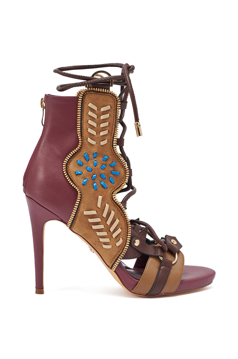 The AZALEA WANG SHAINIA Plum Multi Faux Suede Stiletto Sandal features maroon and brown faux suede, gold accents, blue beading, cutouts, lace-up ankle straps, and open almond toes—a truly eye-catching and intricate design.