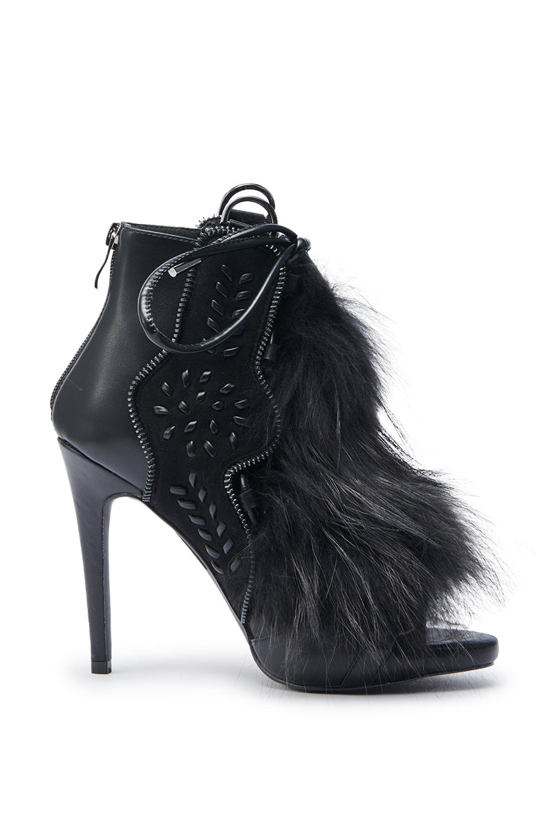The AZALEA WANG SHAINY BLACK FUR SANDAL is a high-heeled black stiletto with cut-out patterns, an open toe, lace-up front, comfort cushion insole, back zipper, and side panel featuring thick textured black fur.