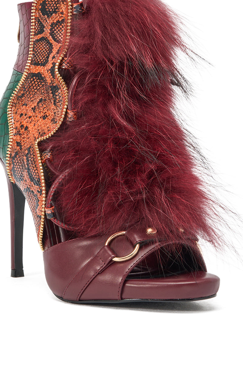 The AZALEA WANG SHAINY SNAKE BURGUNDY MULTI is a striking stiletto sandal with orange and green snake-print panels, burgundy leather, a gold buckle, and bold burgundy fur trim along the front. 5