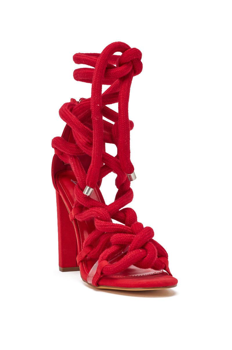 The AKIRA GOLD RED ROPE STRAP SANDAL features bold, chunky red rope straps knotted around the foot and ankle, an open toe, lace-up design, and high block heels for a striking modern look. 5