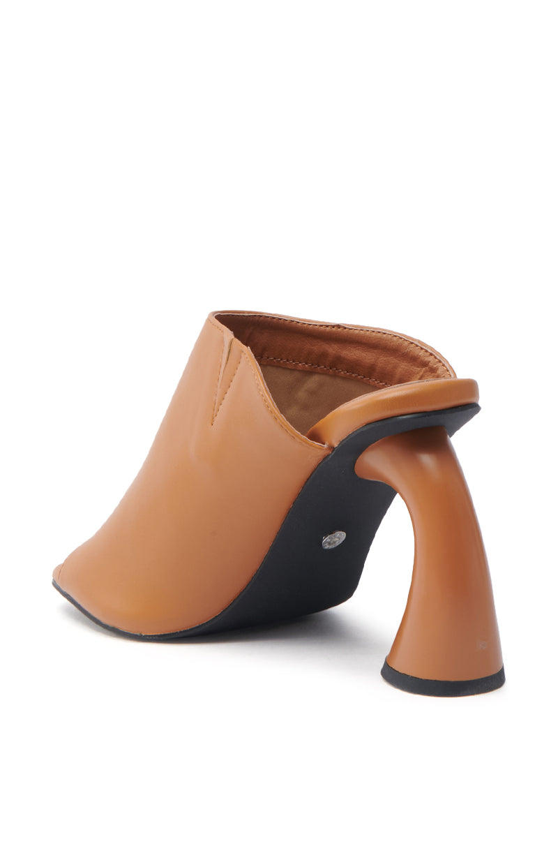 The AZALEA WANG TAN SLIP ON MULE SANDAL is a chic vegan leather mule with a unique curved design, featuring a closed toe, open back, and black chunky heels and soles for a modern, elegant look.